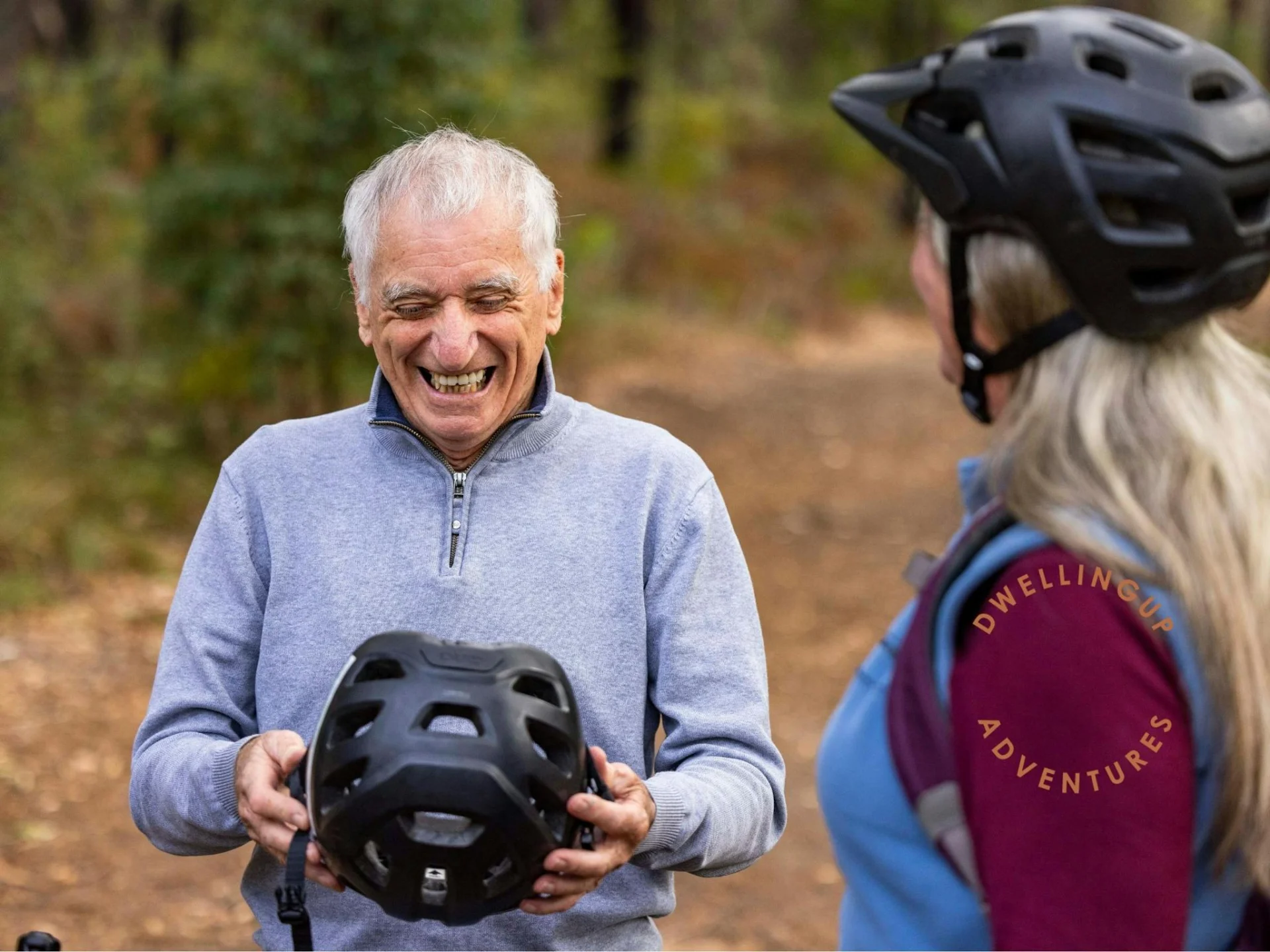 Man and women putting on helmet and laughing
