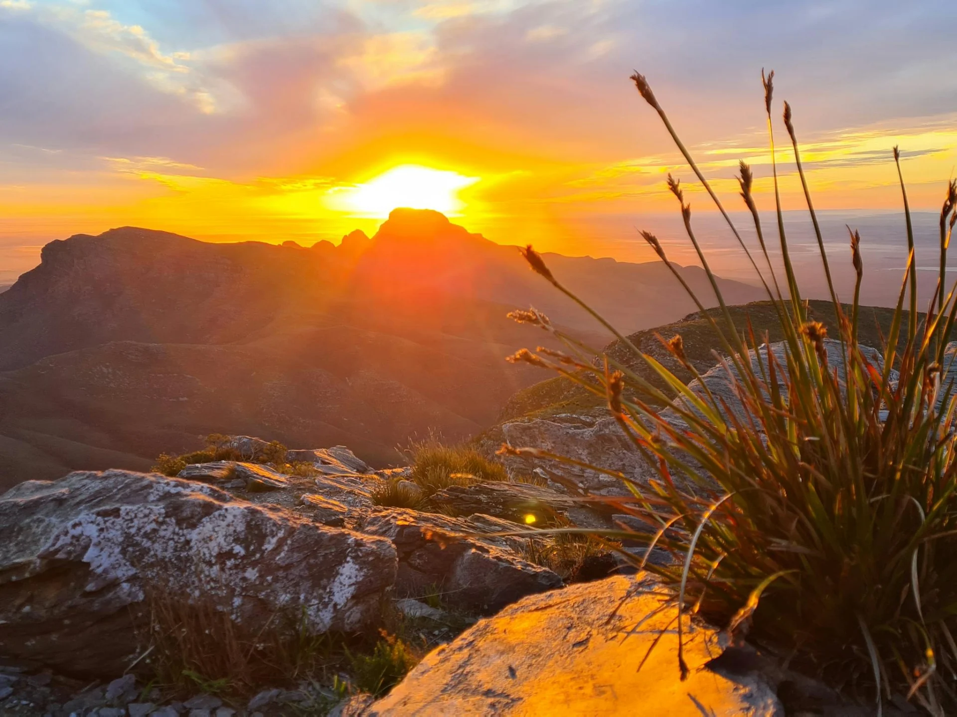 Sun rising behind mountains with orange glow filling the sky