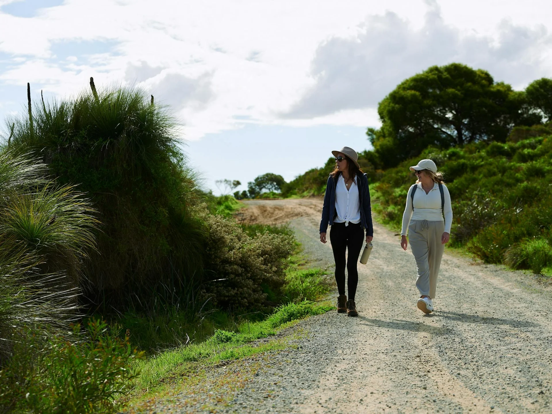 Two women looking at a grass tree