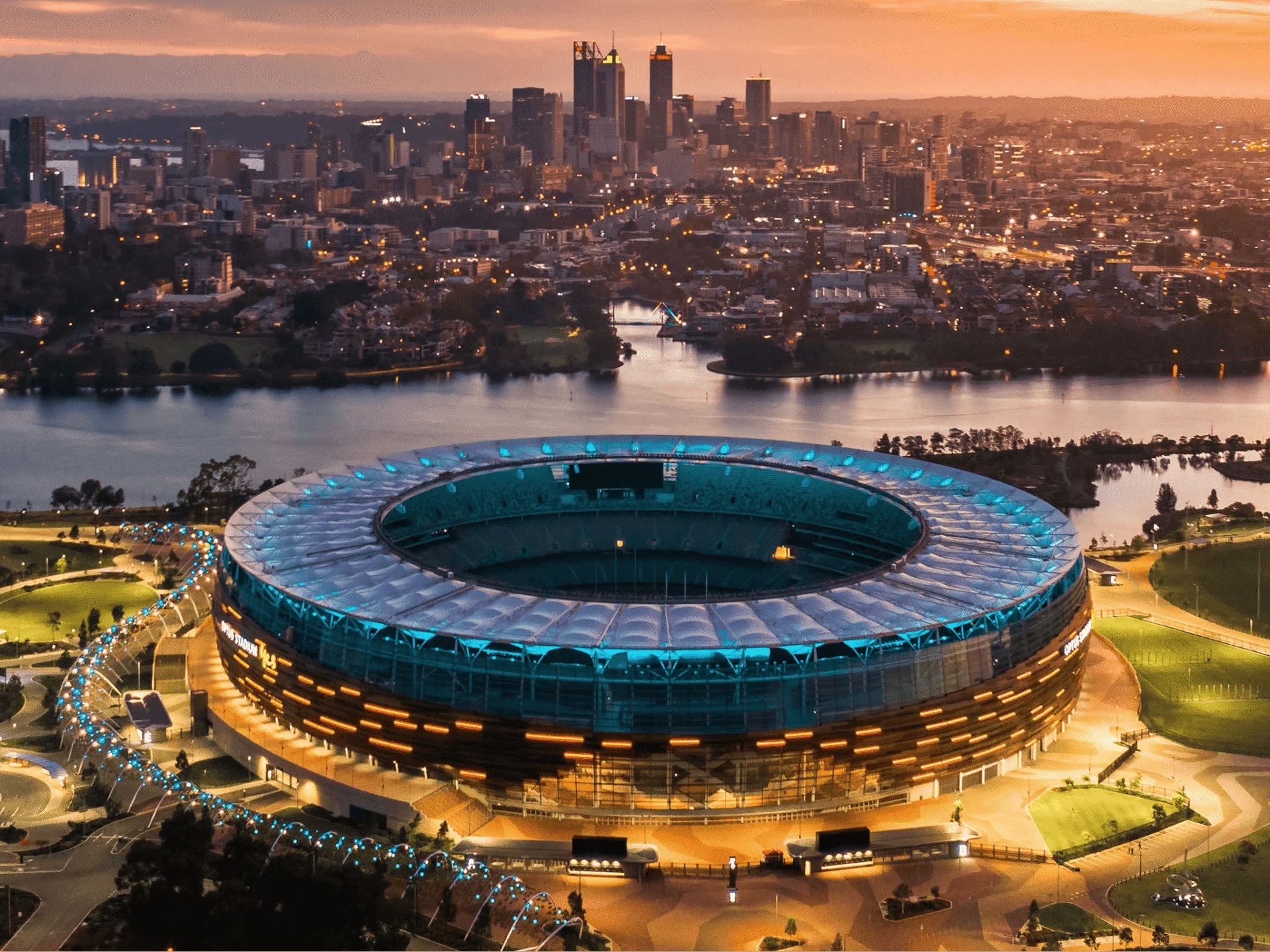 Aerial view of Optus Stadium and Perth skyline at sunset