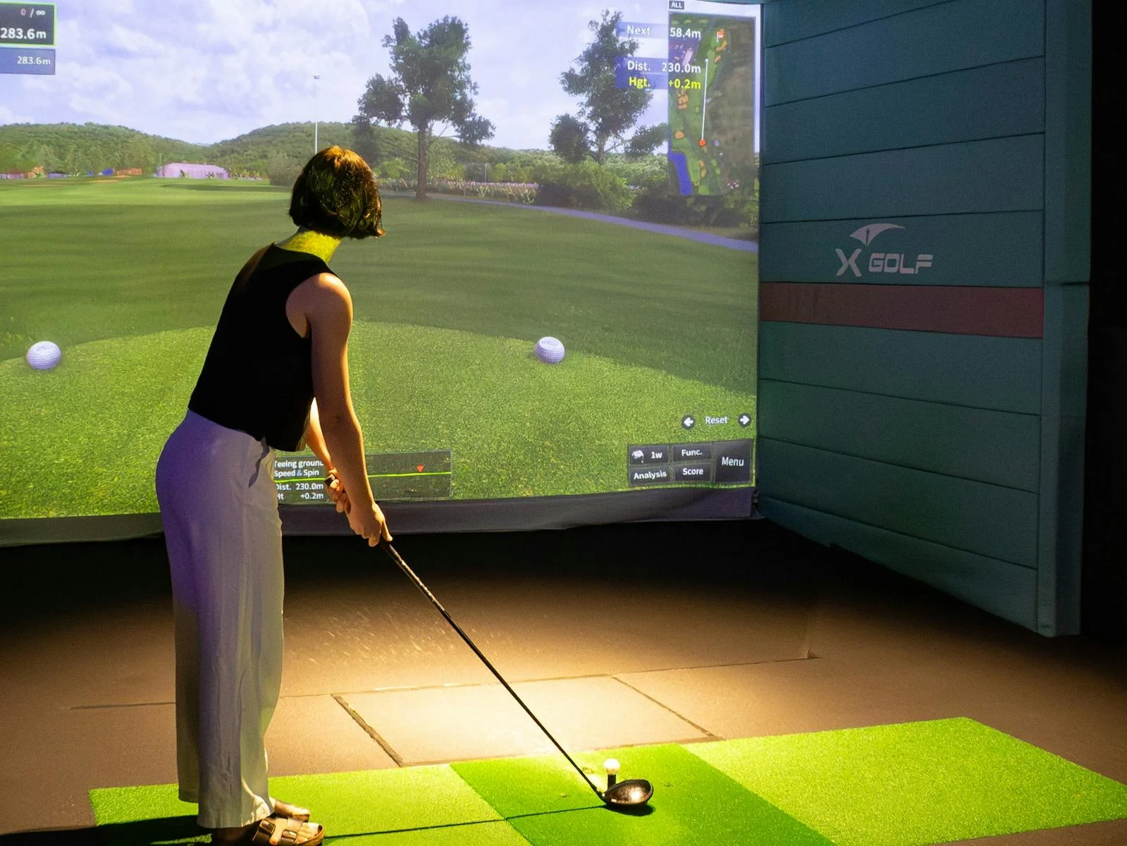 Woman Playing Indoor Golf Simulator at X-Golf Rockingham