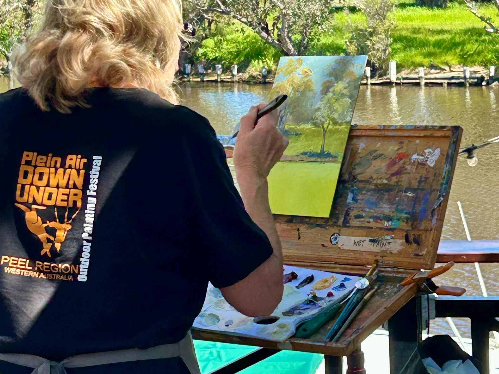 Woman painting outdoors near water