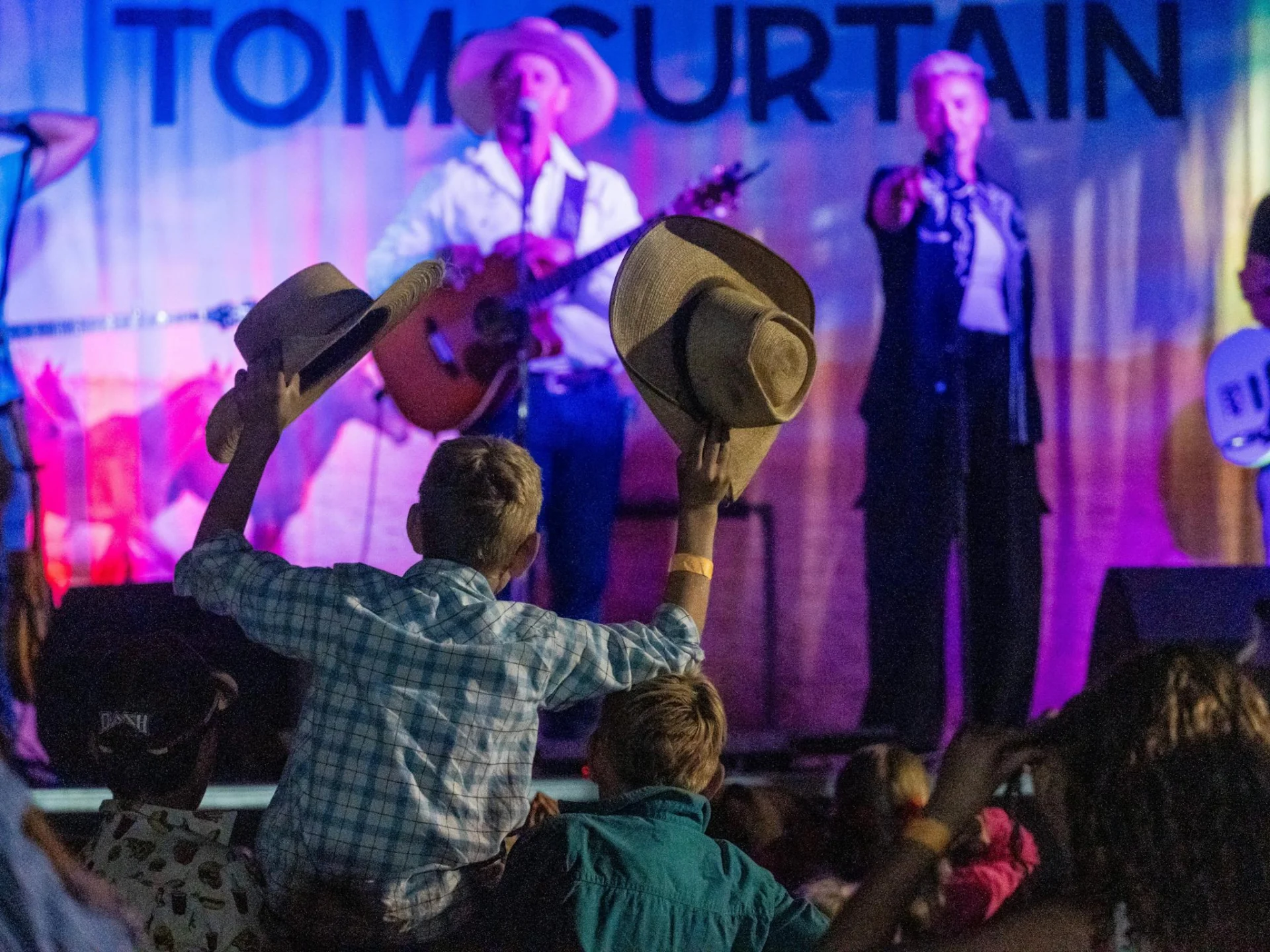 Tom Curtain performing on stage to fans